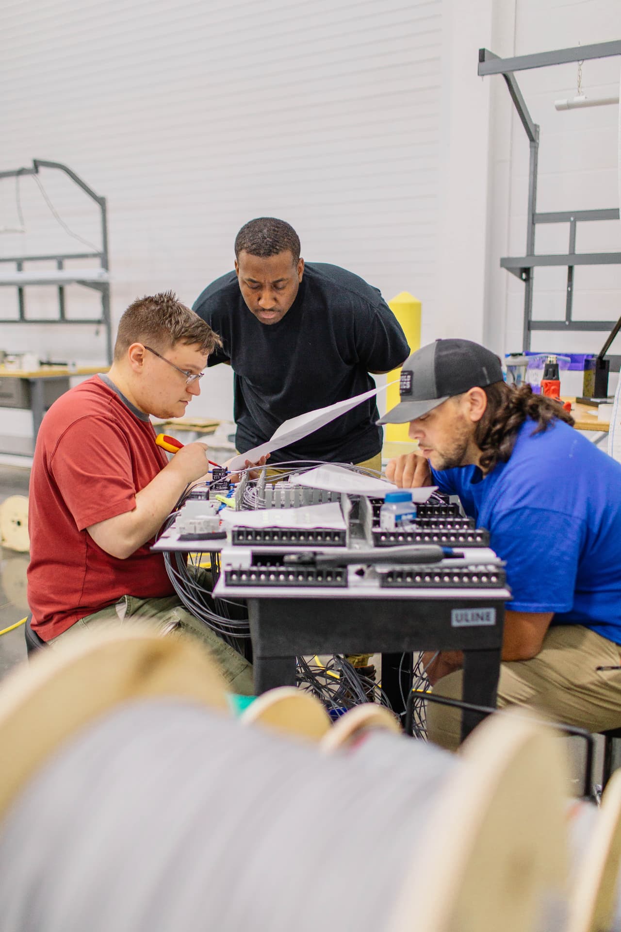 Three Meiden America Switchgear technicians reviewing wiring drawings together