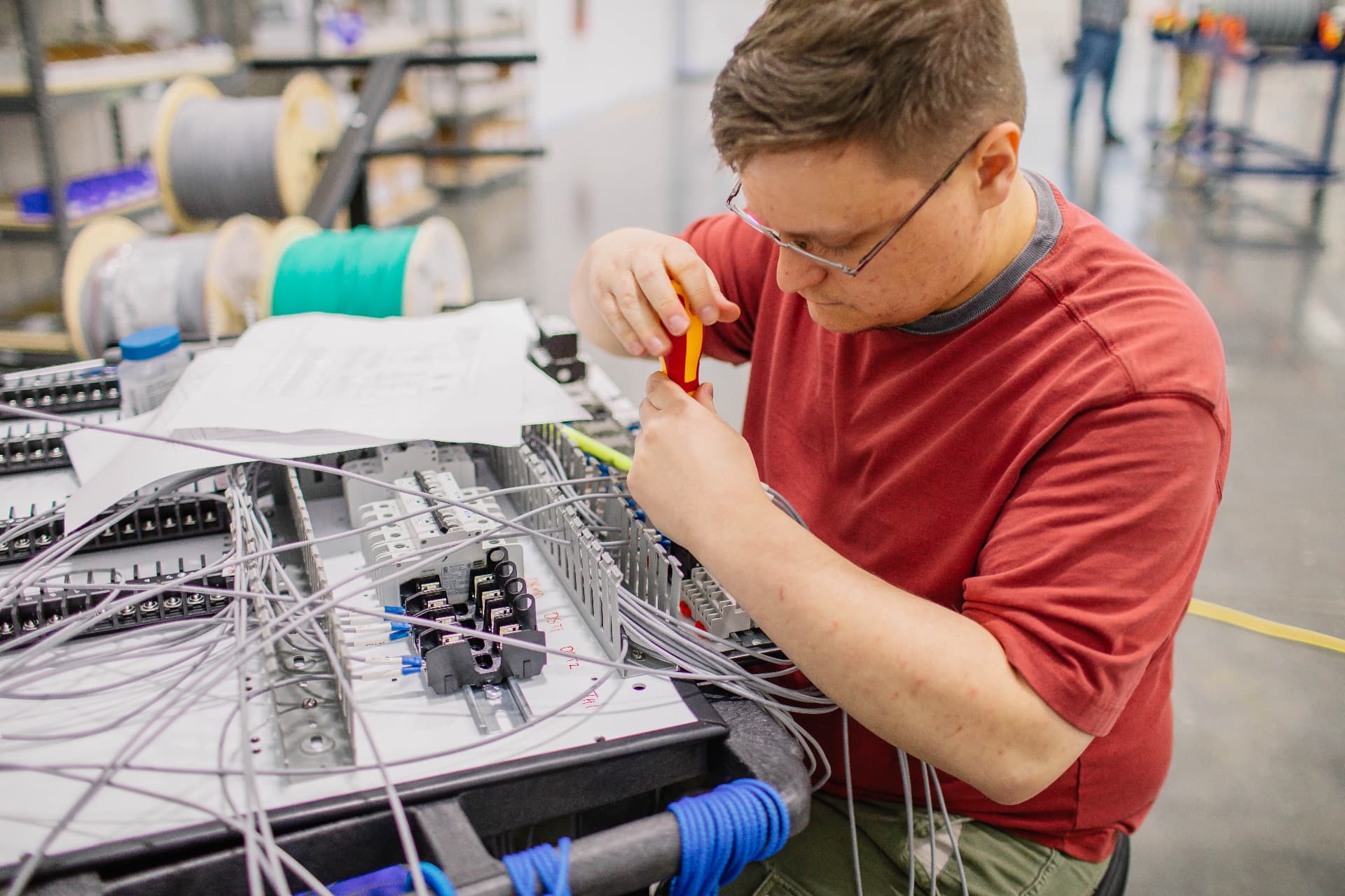 Technician wiring a control panel with a screwdriver