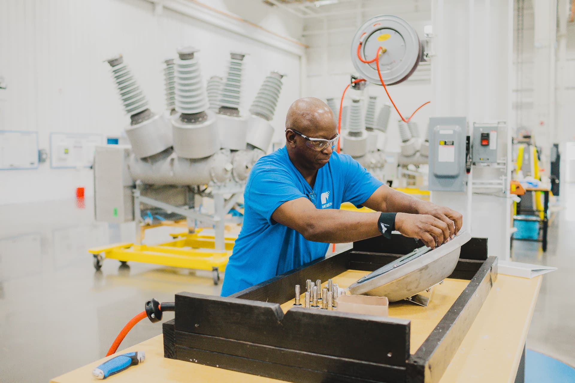 Technician fitting a component at a workbench on the production floor