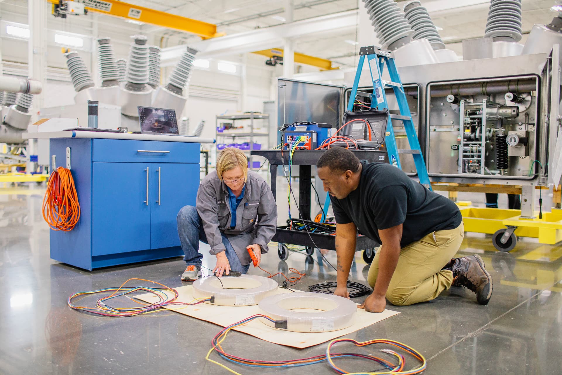 Two engineers testing current transformers on the shop floor