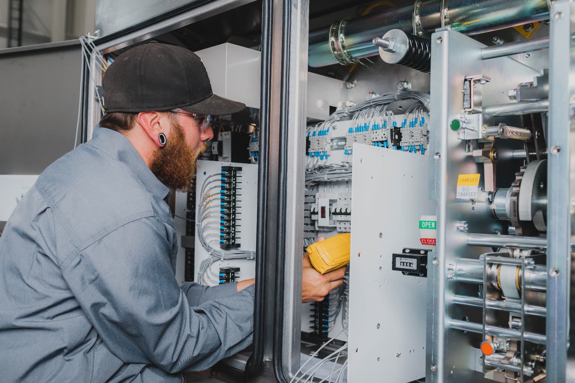 Technician testing a switchgear control cabinet with a meter